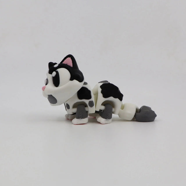 3D printed sensory toy cat with black and white spots on a plain white background