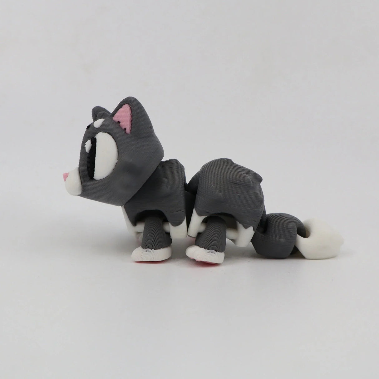 3D printed gray and white cat sensory toy with flexible joints on white background