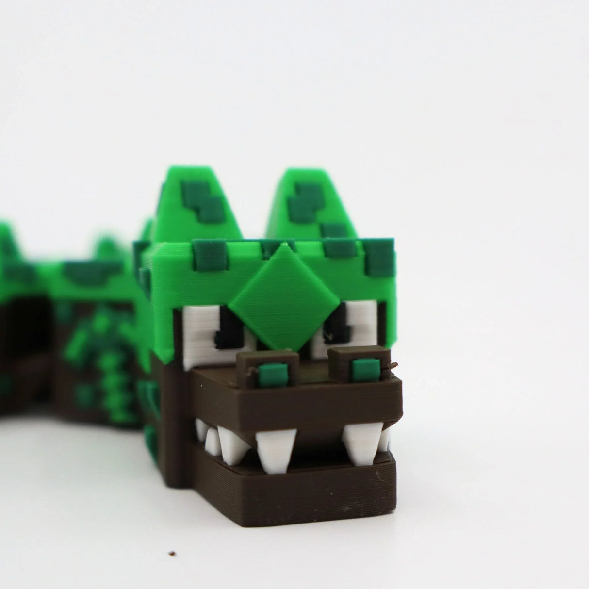 3D printed pixel crocodile fidget toy for sensory play, green and brown with white teeth