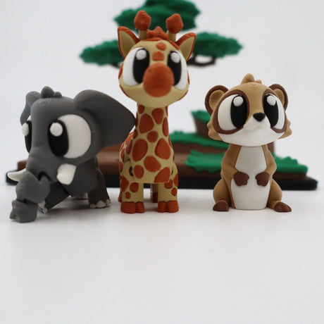 3D printed sensory toy animals including elephant, giraffe, and meerkat with tree background