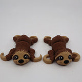 Two brown 3D printed sloth sensory toys with big eyes on a white background.