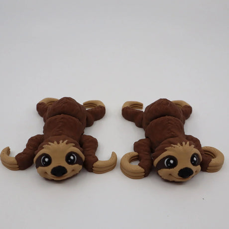 Two brown 3D printed sloth sensory toys with big eyes on a white background.