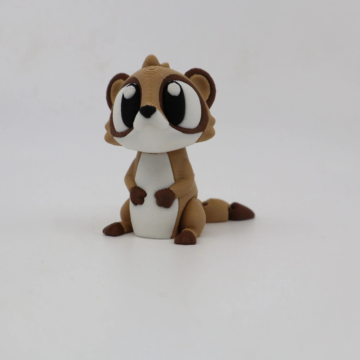 Cute brown and white 3D printed animal sensory toy with large eyes on white background