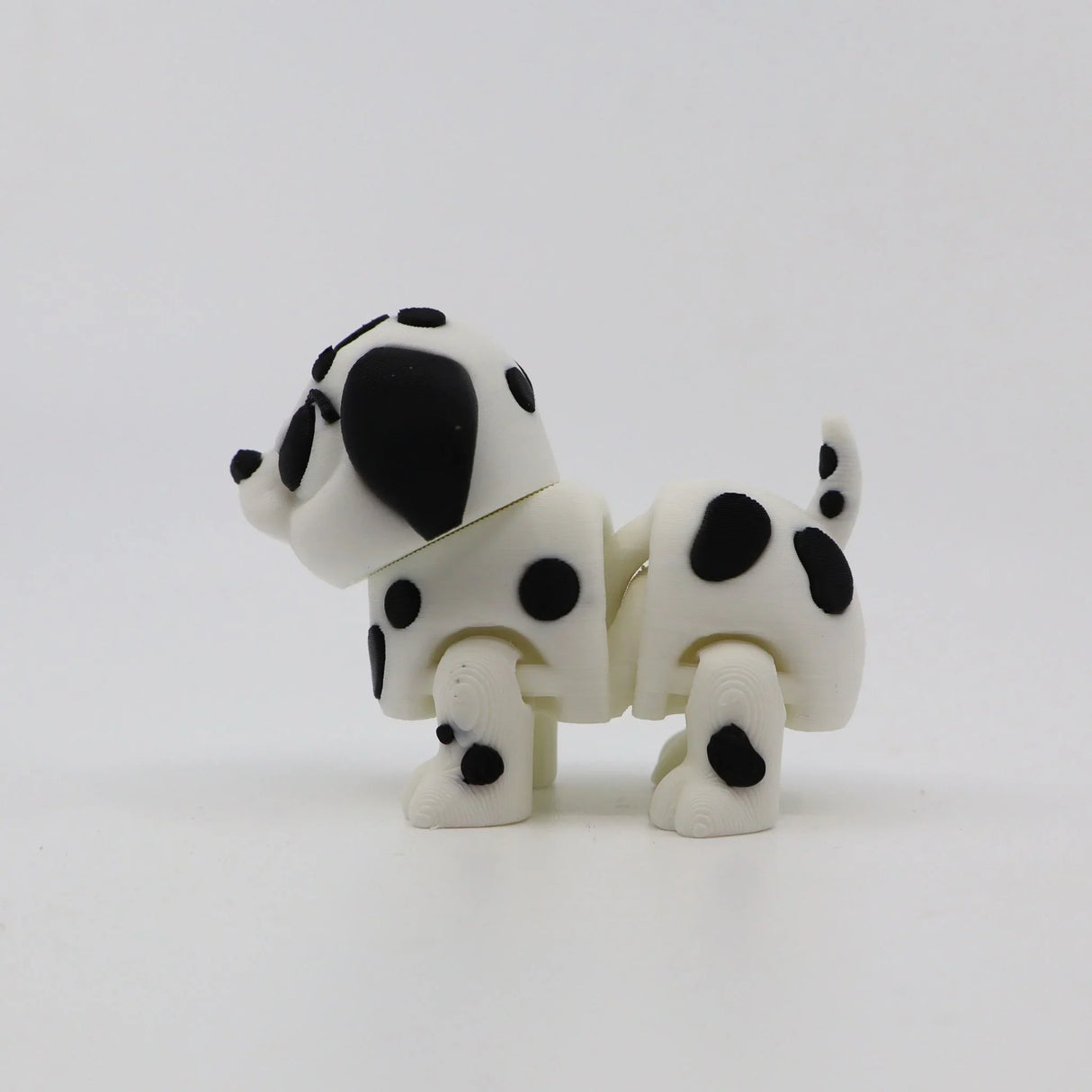 3D printed Dalmatian fidget toy with black spots, designed for sensory play and tactile stimulation