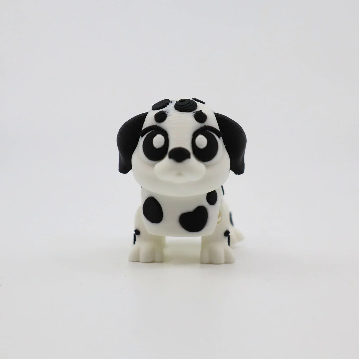 3D printed Dalmatian puppy fidget toy with black spots and big eyes for sensory play