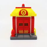 3D printed fire station toy with red doors, yellow roof, and sensory details for kids