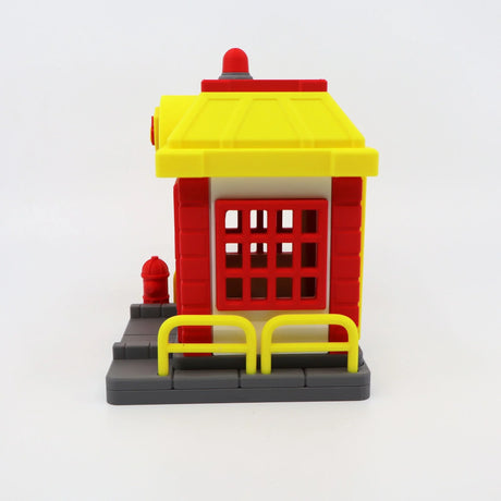 Colorful 3D printed fire station toy with red bricks, yellow roof, and sensory details for kids