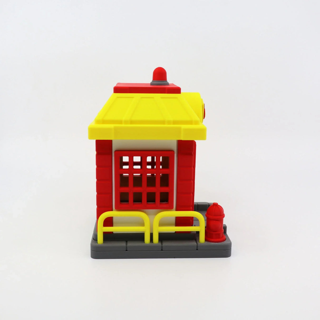 Colorful 3D printed fire station toy with red and yellow details for sensory play
