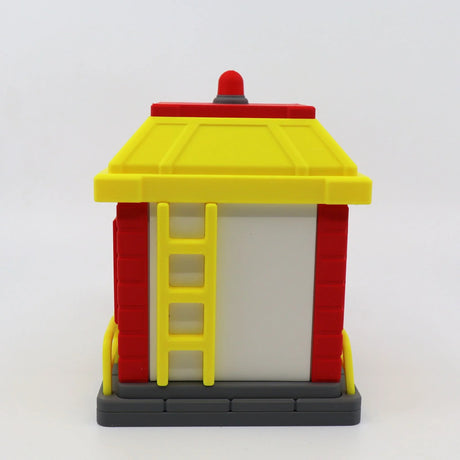 3D printed fire station toy with yellow roof, red walls, and ladder for sensory play