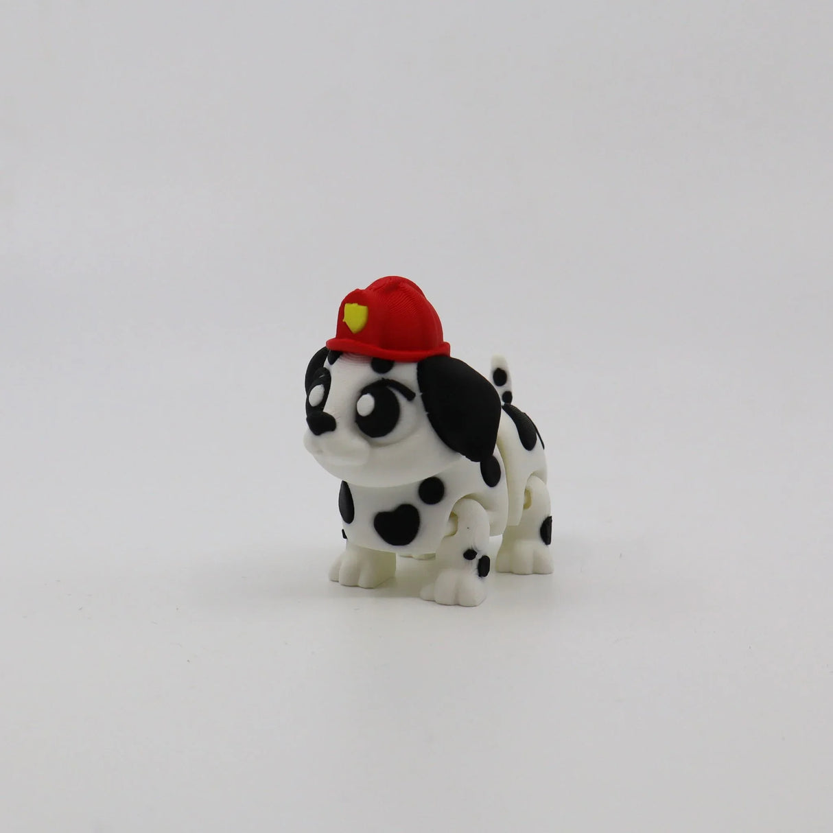 3D printed Dalmatian puppy fidget toy with red firefighter hat, sensory-friendly design for kids
