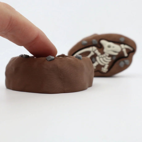 3D printed dinosaur fossil sensory toy with textured surface and embedded stones