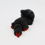 3D printed black sensory toy mole with red nose and claws on white background