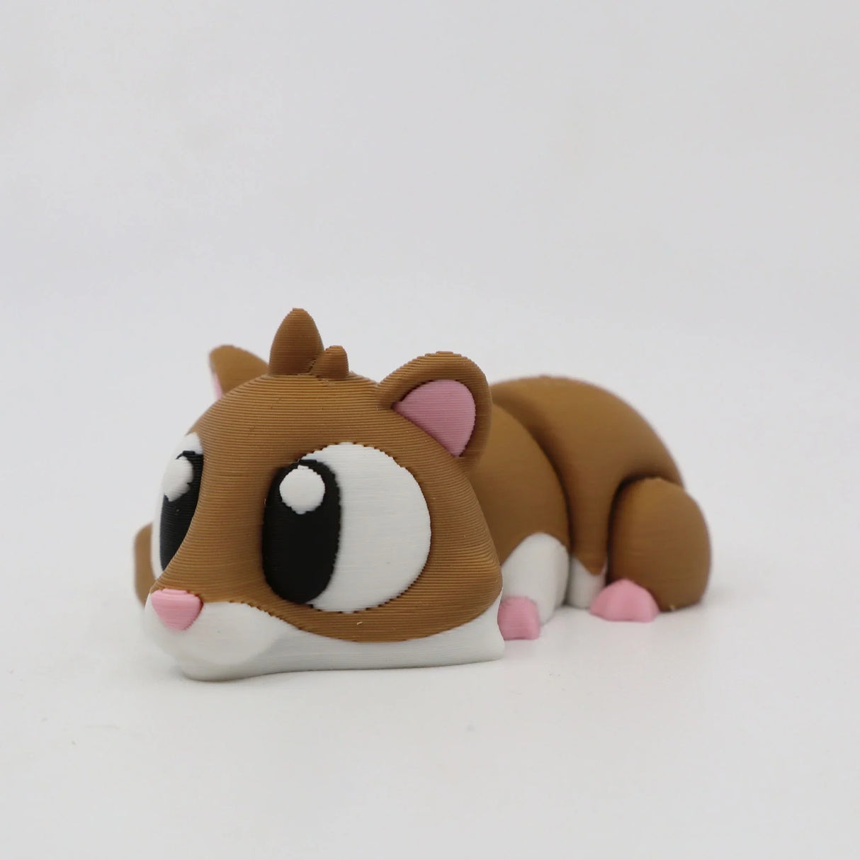 Cute 3D printed hamster sensory toy with large eyes, brown and white body, pink ears and nose