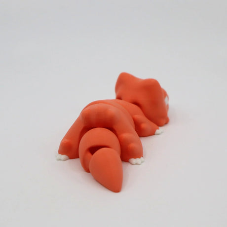 Orange 3D printed sensory toy fox lying down on white background