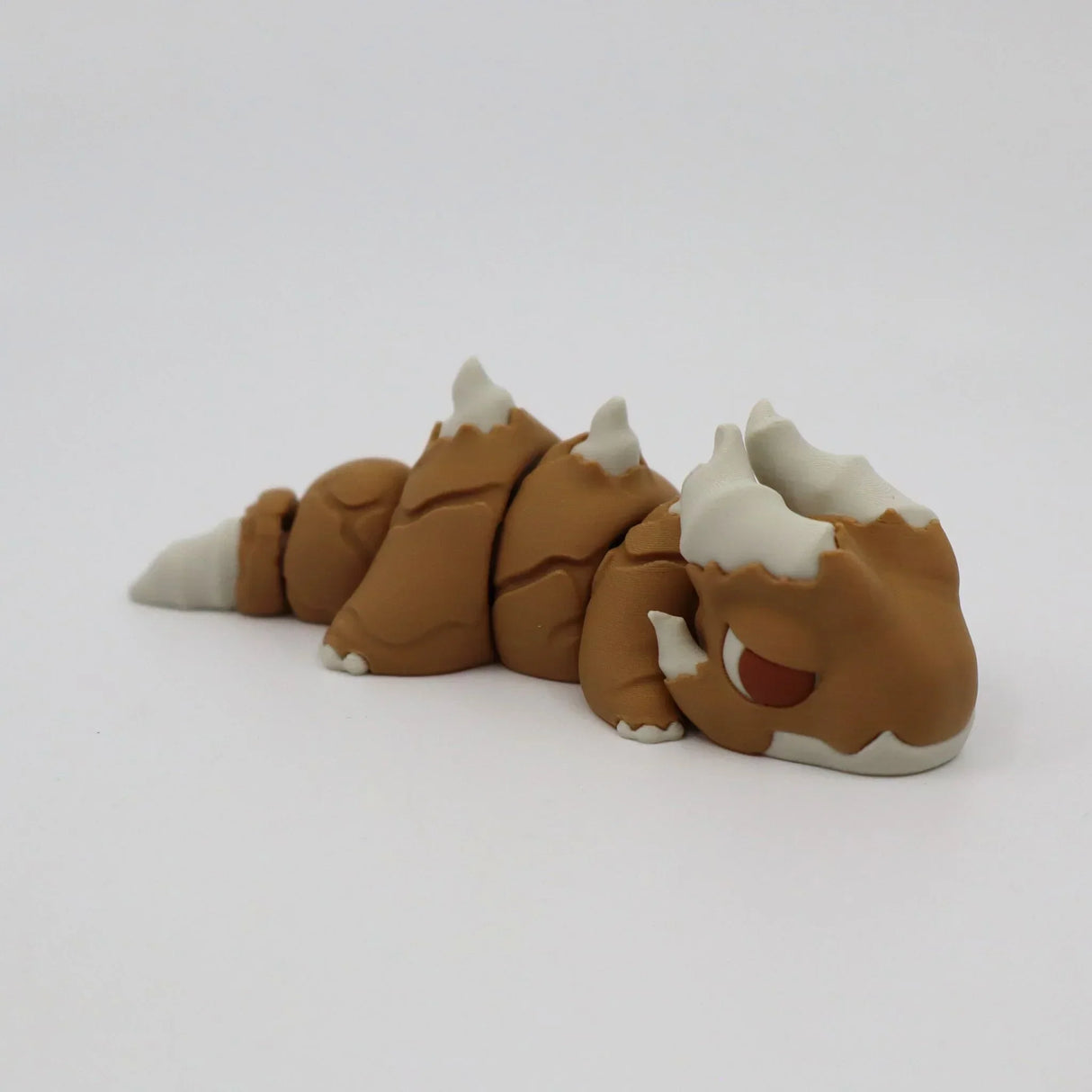 Brown and white 3D printed sensory toy resembling a segmented, fantasy animal on white background.