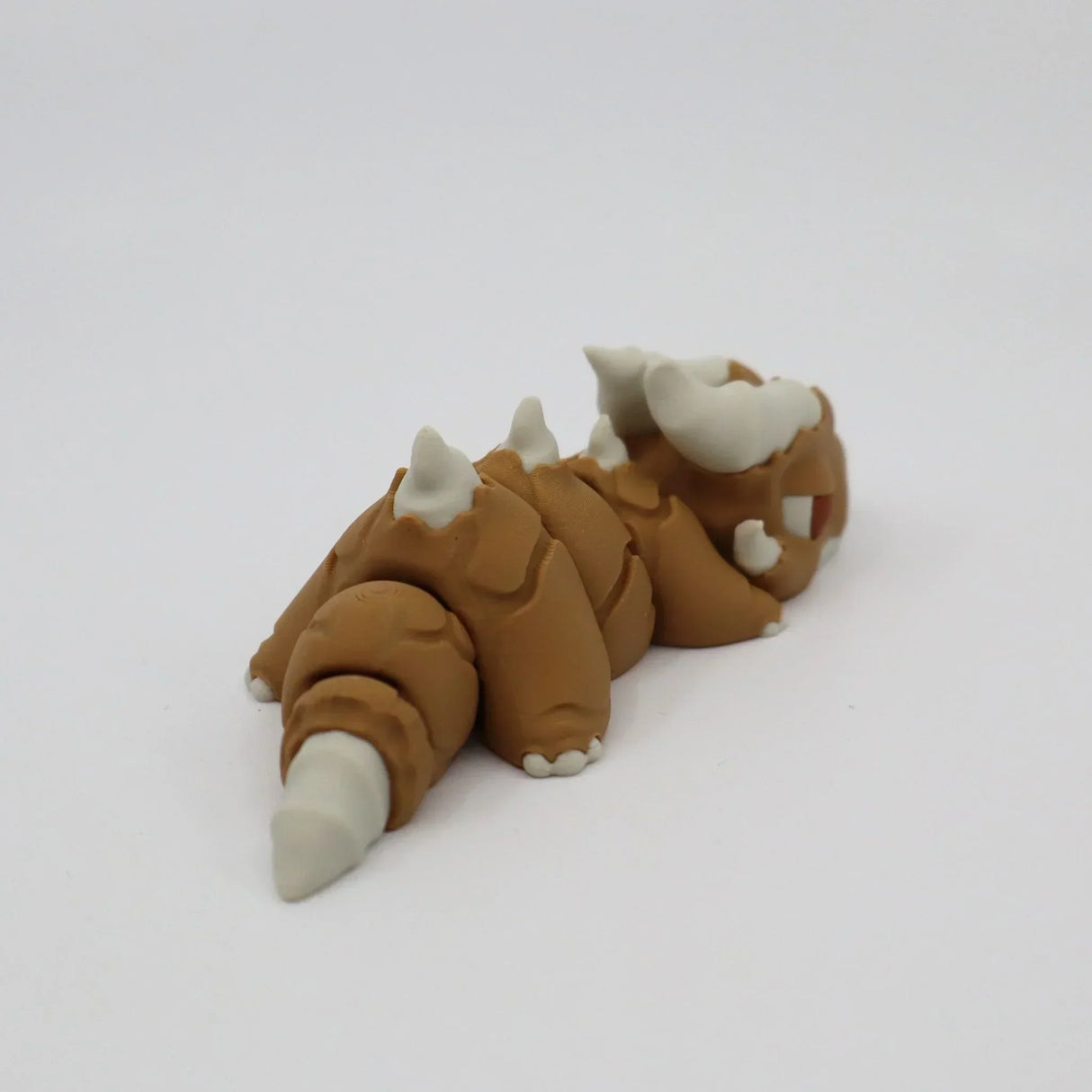 3D printed brown and white sensory toy resembling a segmented, horned creature on white background