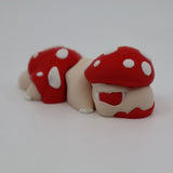 3D printed sensory toy caterpillar with red and white mushroom caps on white background