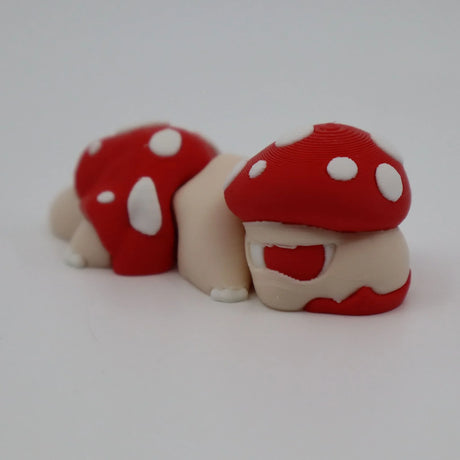 3D printed sensory toy caterpillar with red and white mushroom caps on white background