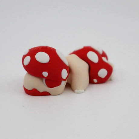 3D printed red and white polka dot mushroom sensory toy on white background