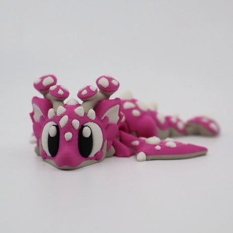 Pink 3D printed flexi dragon toy with white spots, sensory fidget for kids