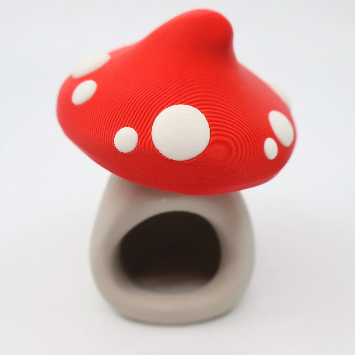 3D printed red and white mushroom house sensory toy with open doorway on white background