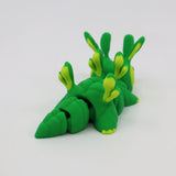 Green and yellow 3D printed sensory toy shaped like a segmented sea slug on white background