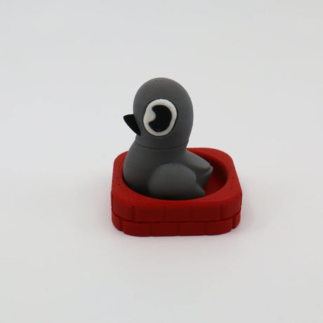 Gray 3D printed penguin fidget toy in red brick base, sensory-friendly design for kids