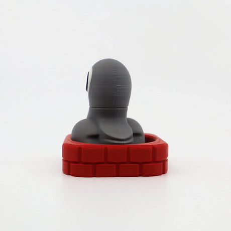 3D printed sensory toy with gray figure in red brick base, ideal for fidgeting and tactile play