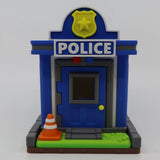 3D printed police station toy with blue walls, yellow badge, and orange cone for sensory play