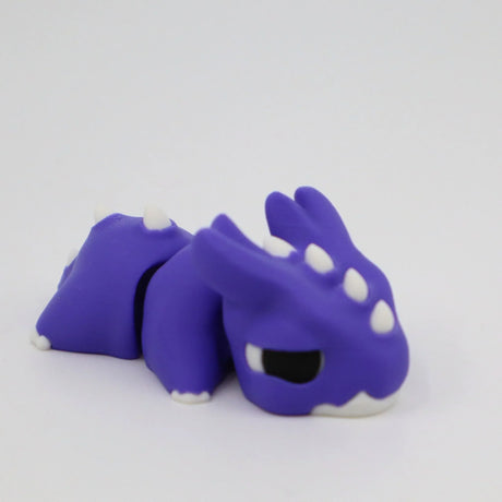 Purple 3D printed dragon sensory toy with white spikes, designed for sensory play
