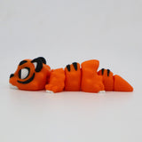 Orange 3D printed tiger sensory toy with black stripes and white accents, laying on side