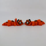 Two orange 3D printed tiger fidget toys facing each other on a white background