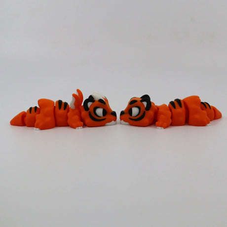 Two orange 3D printed tiger fidget toys facing each other on a white background