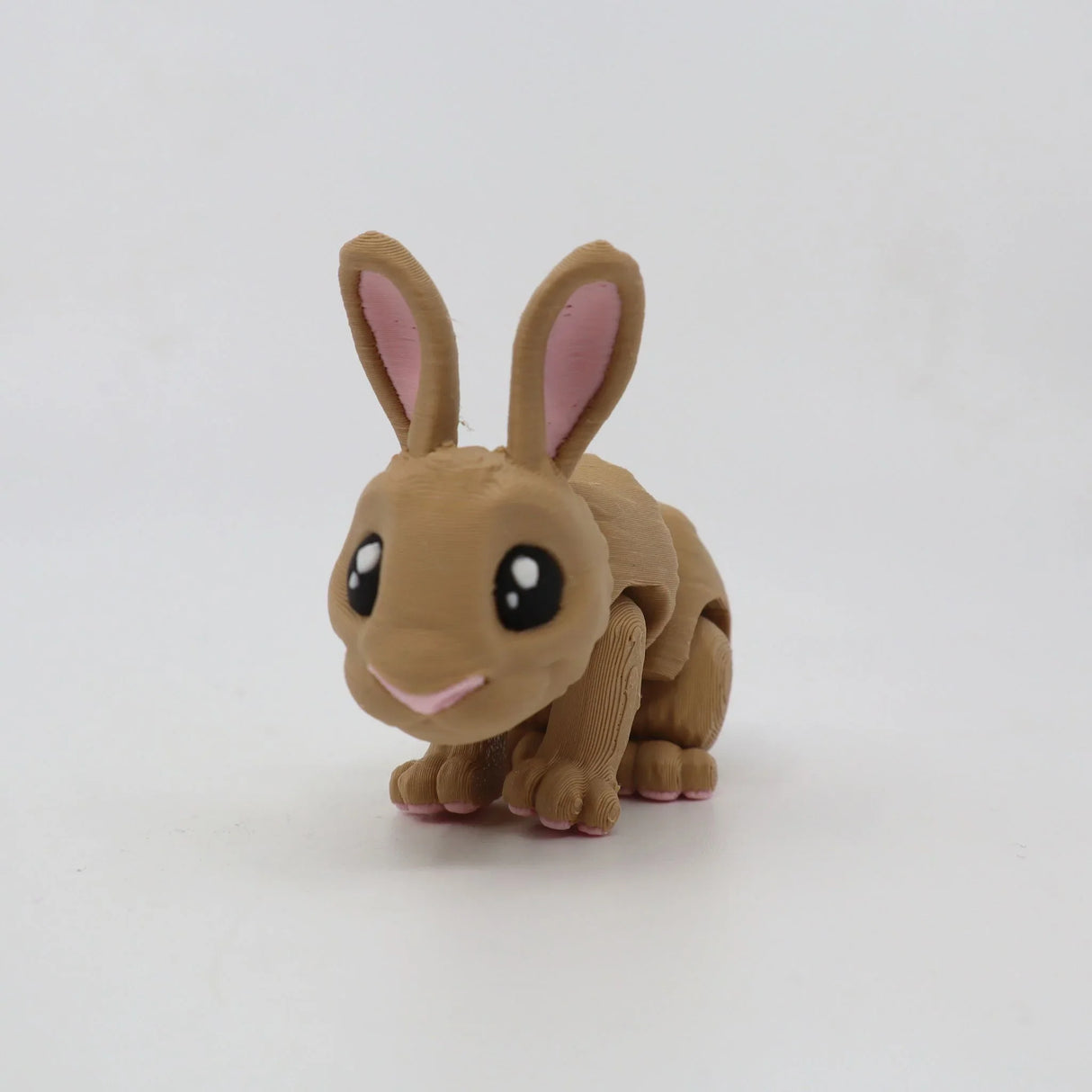 Cute 3D printed brown rabbit sensory toy with jointed limbs and big eyes on a white background