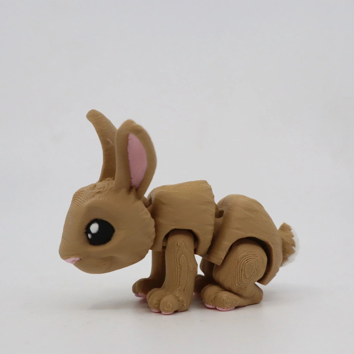 3D printed brown rabbit sensory toy with articulated legs on a white background