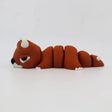 Flexible orange sensory fidget toy shaped like a segmented animal with horns and white paws