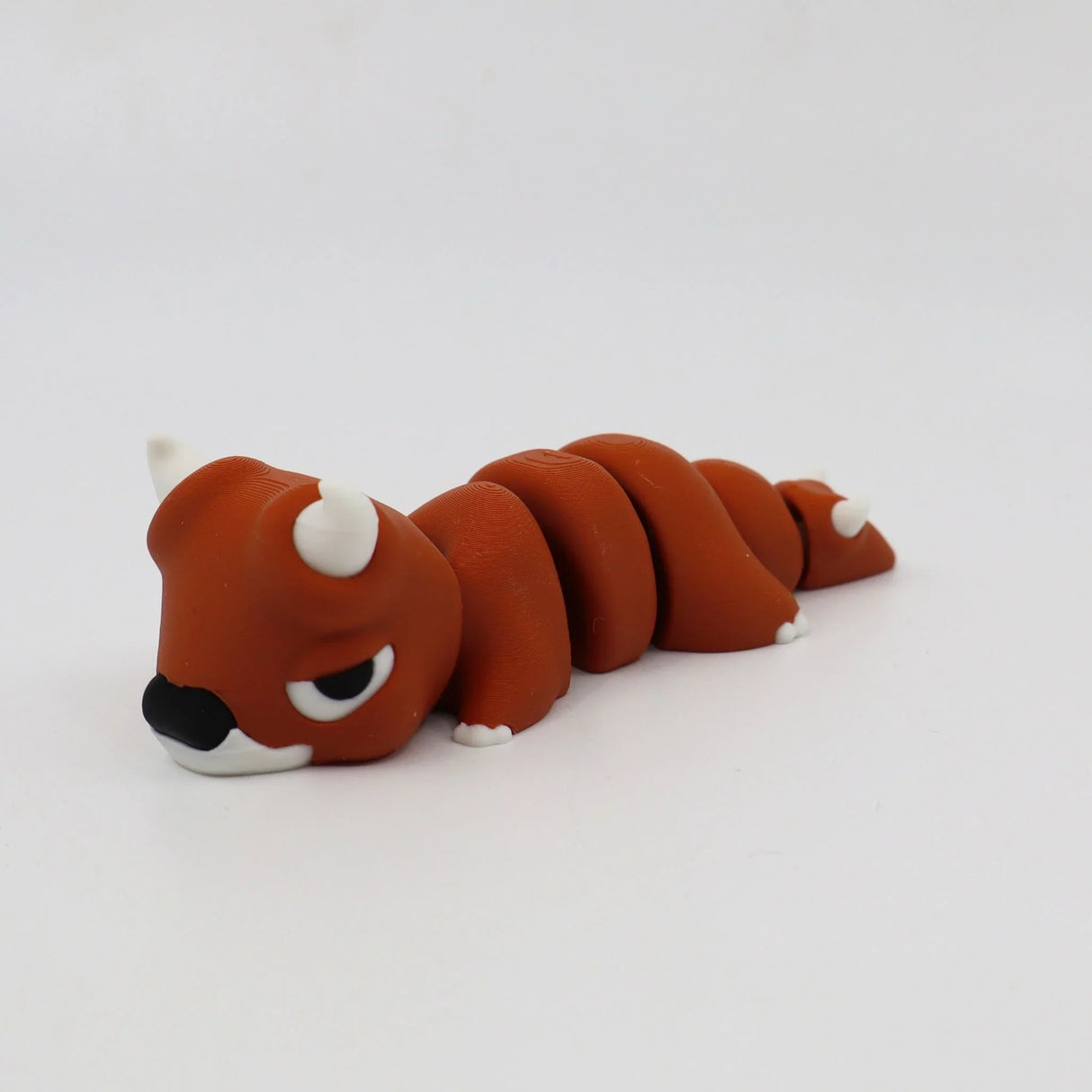 Brown 3D printed sensory toy of a segmented animal with white horns and claws on white background