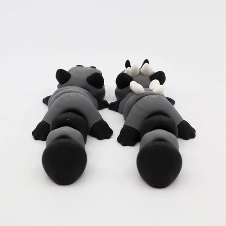 Two gray and black 3D printed sensory animal toys lying side by side on a white background.