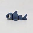 Blue 3D printed shark fidget toy with movable segments on a white background.