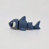 Blue 3D printed shark fidget toy with movable segments on a white background.