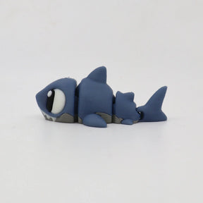 Blue 3D printed shark fidget toy with movable segments on a white background.