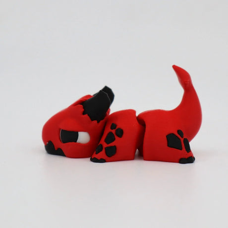 Red and black 3D printed dragon fidget sensory toy on white background
