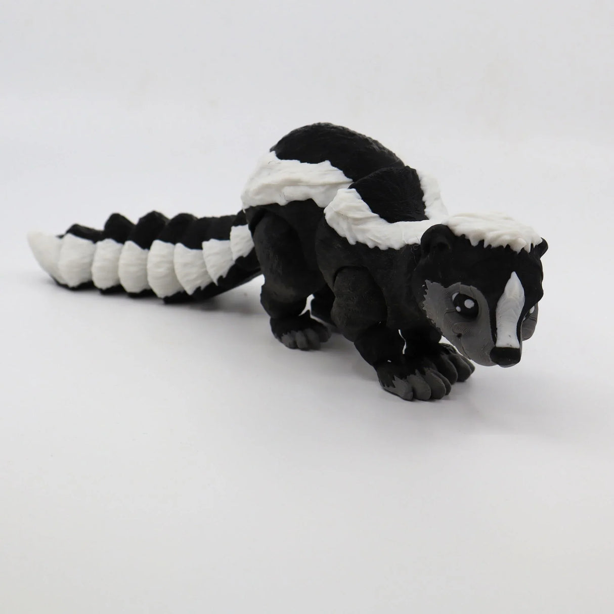 3D printed black and white skunk sensory toy for children on white background