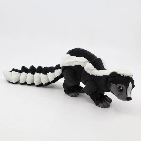 3D printed black and white skunk sensory toy with articulated tail on white background