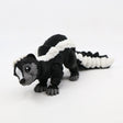 Black and white 3D printed skunk sensory toy with articulated segments on white background