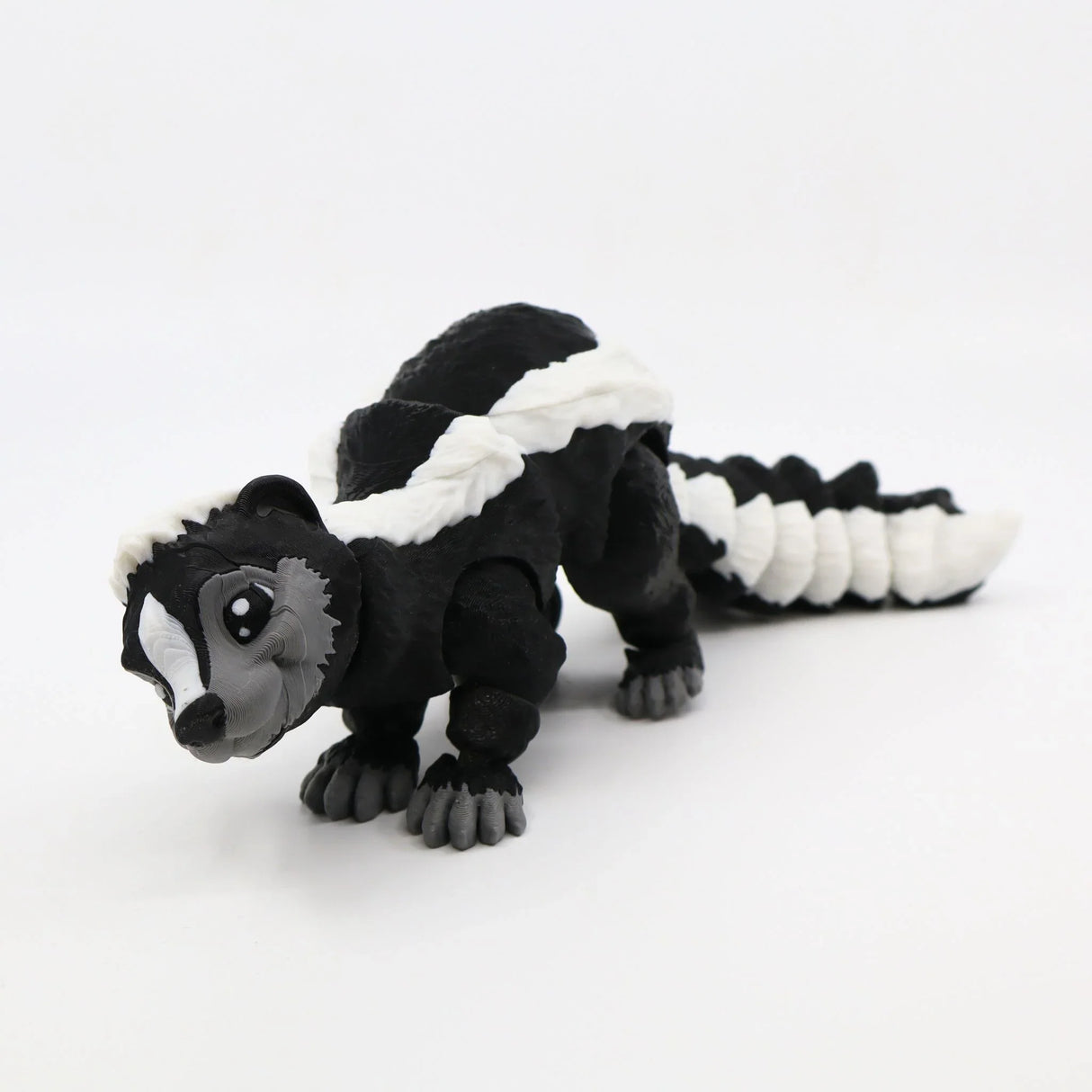 Black and white 3D printed skunk sensory toy with articulated segments on white background