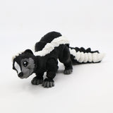 Black and white 3D printed skunk sensory toy with articulated segments on white background