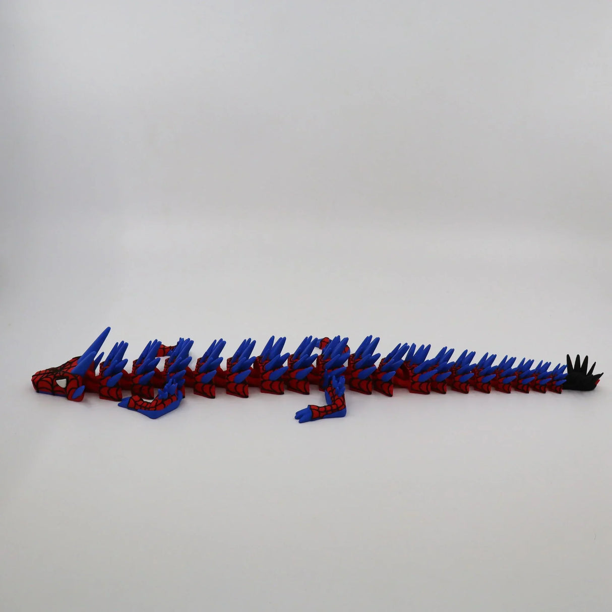 Red and blue 3D printed flexi dragon toy with articulated segments for sensory play