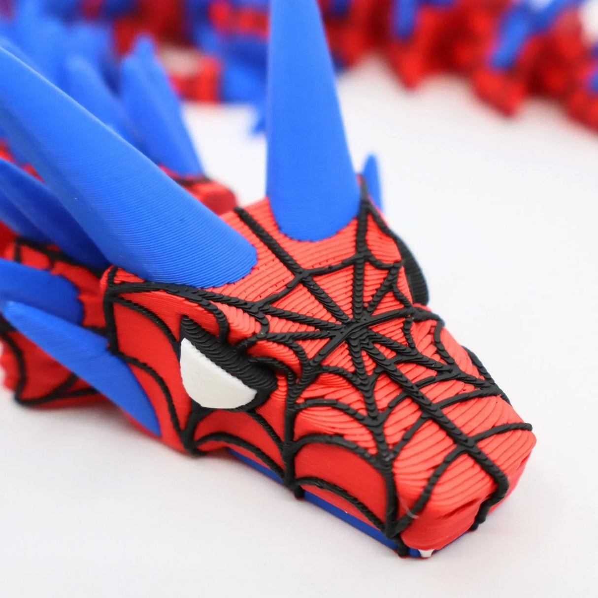 3D printed Spider-Man fidget toy with red, blue, and black web design for sensory play