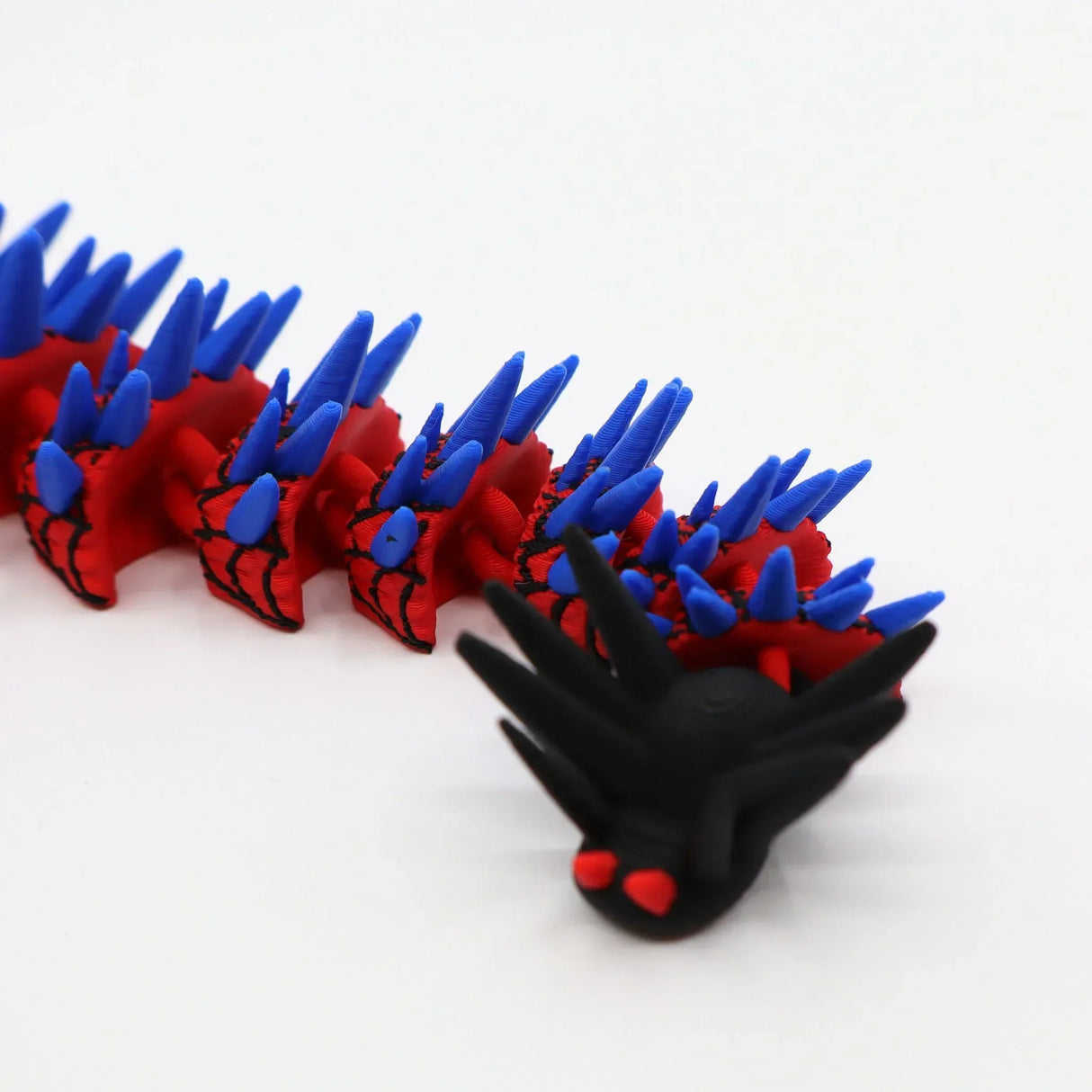Red and blue 3D printed spiky caterpillar fidget toy with black head for sensory play